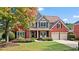 Charming two-story brick home with a well-manicured lawn, mature landscaping, and a welcoming front porch at 8150 Albritton Downs, Cumming, GA 30041