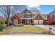 Charming brick home featuring a well-manicured lawn and a two-car garage, all under a beautiful blue sky at 8150 Albritton Downs, Cumming, GA 30041