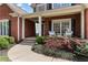 Inviting front porch with cozy seating and well-maintained landscaping, framed by classic brickwork and elegant windows at 8150 Albritton Downs, Cumming, GA 30041