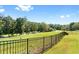 Scenic view of a meticulously maintained golf course, with lush green fairways and a well-kept black metal fence at 8150 Albritton Downs, Cumming, GA 30041