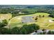 Scenic aerial view of a lush golf course with a tranquil pond and mature trees, offering a serene setting at 8150 Albritton Downs, Cumming, GA 30041