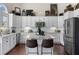 Well-lit kitchen featuring white cabinets, island with seating, stainless steel appliances, and granite countertops at 8150 Albritton Downs, Cumming, GA 30041