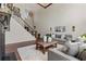Inviting living room with a cozy fireplace, staircase, and bright lighting at 8150 Albritton Downs, Cumming, GA 30041