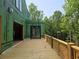 Wide view of the framed deck and black frame door of a new home with a surrounding wooded area at 170 Cedarwood Ln, Roswell, GA 30075