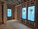 Framed bedroom featuring large black framed windows with a view of the surrounding wooded area at 170 Cedarwood Ln, Roswell, GA 30075