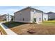 Backyard of a two story home featuring a grass lawn and a small concrete patio and siding at 1857 Holmsey Cir, Conyers, GA 30094