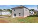 Backyard of a two story home featuring a grass lawn, small concrete patio, and grey siding at 1857 Holmsey Cir, Conyers, GA 30094
