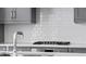 White subway tile backsplash and gas cooktop in modern kitchen at 377 Anders N, Chattahoochee Hills, GA 30268