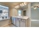 Bright bathroom featuring a dual vanity, a large mirror with lights and a view from the window at 125 Belvedere Rd, Mcdonough, GA 30253