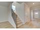 A modern staircase with wood steps and metal railings leads to the upper level, bathed in natural light at 125 Belvedere Rd, Mcdonough, GA 30253