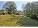 Backyard view of a home with lawn and landscaping surrounded by mature trees and a wooden fence at 1366 Emory Ne Rd, Atlanta, GA 30306