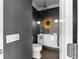 Modern powder room, dark gray walls, gold accents, and a sunburst mirror at 3475 Oak Valley Rd # 2820, Atlanta, GA 30326