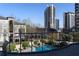 Balcony view of the pool with lounge chairs and landscaping with luxury high rise buildings in the background at 3475 Oak Valley Rd # 2820, Atlanta, GA 30326