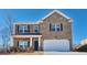 Two-story brick home with a two-car garage and landscaping at 5423 Flat Rock Pt, Stonecrest, GA 30038