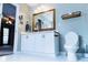 Bright bathroom features a white vanity, gold framed mirror, and white tile floors at 295 Whitby Dr, Douglasville, GA 30134