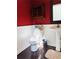 A full bathroom with a sink, mirror, toilet, and red walls at 295 Whitby Dr, Douglasville, GA 30134