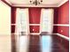 Bright dining room with hardwood floors, red walls, crown molding, and natural light from two windows at 295 Whitby Dr, Douglasville, GA 30134
