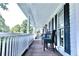 Inviting covered front porch with dark wood flooring and chairs for relaxing outdoors at 295 Whitby Dr, Douglasville, GA 30134