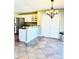 Kitchen with white cabinets, stainless steel refrigerator, and tile floors under a chandelier at 295 Whitby Dr, Douglasville, GA 30134