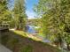 Scenic backyard view overlooking the lake with a private dock and lush trees at 6095 Blackberry Ln, Buford, GA 30518