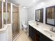 Bathroom featuring double vanity, glass shower with decorative tile, and neutral paint at 6095 Blackberry Ln, Buford, GA 30518