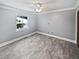 Bright bedroom with wood-look floors, neutral walls, a ceiling fan, and a large window at 6095 Blackberry Ln, Buford, GA 30518