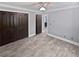 Spacious bedroom featuring wood-look floors, gray walls, ceiling fan and double-door closet at 6095 Blackberry Ln, Buford, GA 30518