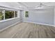 A bright bedroom with wood floors, a ceiling fan, and natural light from the two large windows at 6095 Blackberry Ln, Buford, GA 30518