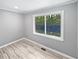 Cozy bedroom with natural light and wood-look floors with an exterior view at 6095 Blackberry Ln, Buford, GA 30518