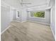 A bright bedroom with wood floors, a ceiling fan, and natural light from the two large windows at 6095 Blackberry Ln, Buford, GA 30518