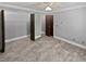 Bedroom with an open closet with built in shelving and plenty of storage and wood-look flooring at 6095 Blackberry Ln, Buford, GA 30518