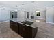 Modern kitchen island with dark cabinets, granite countertops, and sleek cooktop in an open layout at 6095 Blackberry Ln, Buford, GA 30518