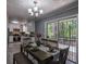 Bright dining area with a modern chandelier, table set for four, leading to a full kitchen and backyard access at 1705 Atherton Dr, Decatur, GA 30035