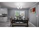 Dining area featuring modern chandelier, table set for four, with a view to the backyard at 1705 Atherton Dr, Decatur, GA 30035