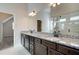 Bathroom featuring double vanity with granite countertop, dark cabinets, and a walk-in shower at 409 West March Cir, Loganville, GA 30052