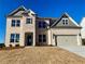 Two-story home with neutral brick, covered entry and two car garage at 409 West March Cir, Loganville, GA 30052