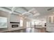 Bright living room featuring a brick fireplace, coffered ceilings, and wood floors that transition into the kitchen area at 409 West March Cir, Loganville, GA 30052