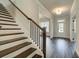 Staircase with dark wood treads, white risers, and black metal spindles at 409 West March Cir, Loganville, GA 30052