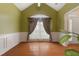 Dining room featuring hardwood floors, wainscoting and a window with elegant curtains at 532 Goldfinch Way, Stockbridge, GA 30281