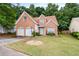 Charming brick home featuring a manicured lawn, two-car garage, and beautiful landscaping at 532 Goldfinch Way, Stockbridge, GA 30281