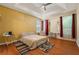Main bedroom featuring tray ceiling, hardwood floors and a large window at 532 Goldfinch Way, Stockbridge, GA 30281