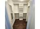 Organized walk-in closet featuring hardwood floors, built-in shelving, and a full-length mirror at 1100 Howell Mill Rd # 404, Atlanta, GA 30318