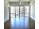 Bright living room features hardwood floors and sliding glass doors showcasing the urban view at 1100 Howell Mill Rd # 404, Atlanta, GA 30318