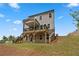 Multi-story home showcasing a wooden deck with staircase with brick foundation and lush backyard at 7530 Homer Dr, Cumming, GA 30028