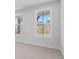 Bright bedroom with neutral carpet, natural light through windows, and partial view of a landscaped backyard at 7530 Homer Dr, Cumming, GA 30028