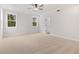 Spacious bedroom featuring a ceiling fan, plush carpet, and natural light at 7530 Homer Dr, Cumming, GA 30028