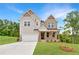 Charming two-story home with mixed siding, brick accents, and inviting front porch on a lush, green lawn at 7530 Homer Dr, Cumming, GA 30028