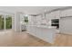 Bright kitchen featuring white cabinetry, a large center island, stainless steel appliances, and access to the deck at 7530 Homer Dr, Cumming, GA 30028