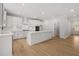 Spacious kitchen with white cabinetry, a large center island, stainless steel appliances, and hardwood floors at 7530 Homer Dr, Cumming, GA 30028