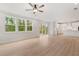 Open concept living room with kitchen, fireplace, large windows and a ceiling fan at 7530 Homer Dr, Cumming, GA 30028